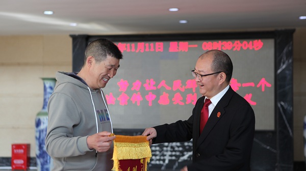 当事人将锦旗送到法官手中.jpg 当事人将锦旗送到法官手中.jpg